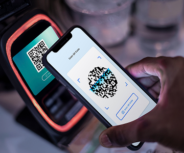Phone scanning QR code at payment terminal